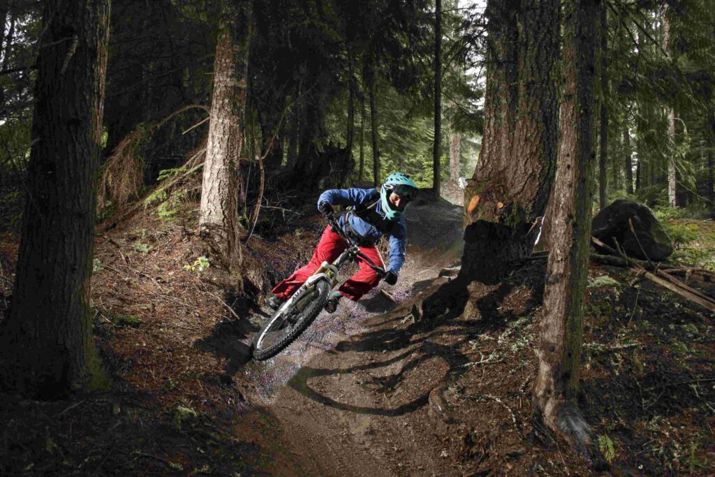 Maastopyöräilijä ajaa lujaa metsäpolulla.